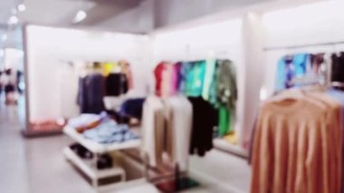 Moda, perakende ve dükkan. Lüks alışveriş merkezindeki giyim mağazasının iç görünüşü bulanık. Yüksek kalite 4k görüntü