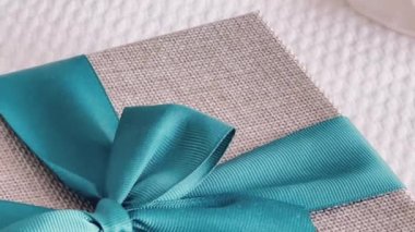 Holiday present and luxury online shopping delivery, wrapped linen gift box with blue ribbon on bed in bedroom, chic countryside style, close-up