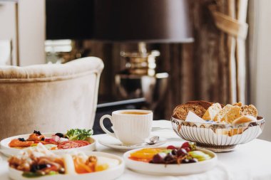 Lüks otel ve beş yıldızlı oda servisi, çeşitli yemek tabakları, ekmek ve kahve seyahat ve konukseverlik markası olarak oda kahvaltısı.