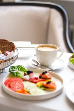 Lüks otel ve beş yıldızlı oda servisi, çeşitli yemek tabakları, ekmek ve kahve seyahat ve konukseverlik markası olarak oda kahvaltısı.