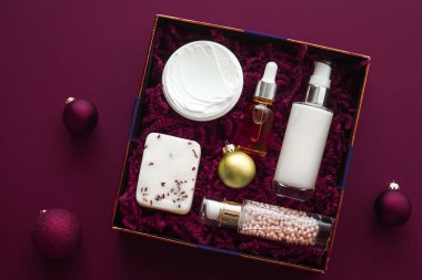 Noel hediyesi seti, xmas bayramı güzellik kutusu abonelik paketi ve lüks cilt ürünleri düz döşeme, mor arka planda kozmetik daire, tatil hediyesi olarak kozmetik ürünler veya alışveriş teslimatı, üst düzey