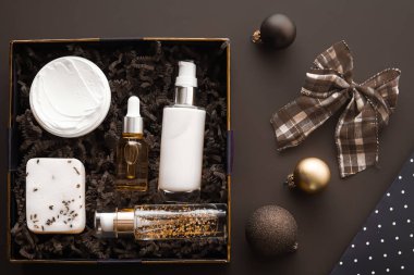 Noel hediyesi seti, xmas bayramı güzellik kutusu abonelik paketi ve lüks cilt ürünleri düz döşeme, kozmetik daire koyu arka plan, kozmetik bayram hediyesi veya alışveriş teslimatı olarak yatıyordu.