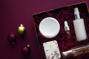 Noel hediyesi seti, xmas bayramı güzellik kutusu abonelik paketi ve lüks cilt ürünleri düz döşeme, mor arka planda kozmetik daire, tatil hediyesi olarak kozmetik ürünler veya alışveriş teslimatı, üst düzey