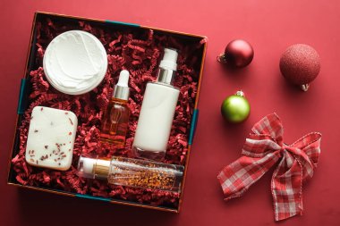 Noel hediyesi seti, xmas bayramı güzellik kutusu abonelik paketi ve lüks cilt ürünleri düz döşeme, mercan arka planda kozmetik daire, tatil hediyesi olarak kozmetik ürünler veya alışveriş teslimatı, üst düzey