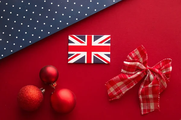 Christmas holiday tradition in United Kingdom and happy holidays flat lay, british flag, xmas ornaments and decoration on festive red background as flatlay design, top view