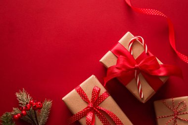 Noel hediyeleri, boks günü ve geleneksel bayram hediyeleri düz konum, kırmızı arka planda klasik Noel hediye kutuları, bayram süsleri ve düz dizayn dekorasyonları ile paketlenmiş
