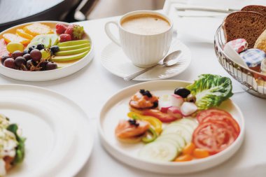 Lüks otel ve beş yıldızlı oda servisi, çeşitli yemek tabakları, ekmek ve kahve seyahat ve konukseverlik markası olarak oda kahvaltısı.