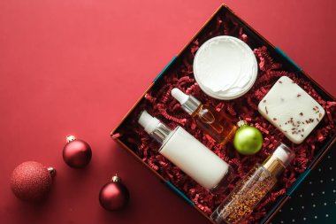 Noel hediyesi seti, xmas bayramı güzellik kutusu abonelik paketi ve lüks cilt ürünleri düz döşeme, mercan arka planda kozmetik daire, tatil hediyesi olarak kozmetik ürünler veya alışveriş teslimatı, üst düzey
