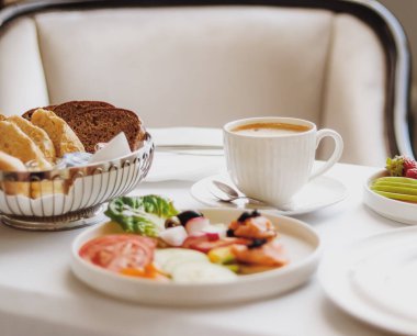 Lüks otel ve beş yıldızlı oda servisi, çeşitli yemek tabakları, ekmek ve kahve seyahat ve konukseverlik markası olarak oda kahvaltısı.