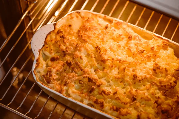 Cooking comfort food and traditional English cuisine, fish pie baking in the oven in countryside kitchen, homemade recipe idea
