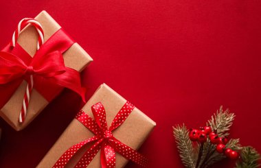 Noel hediyeleri, boks günü ve geleneksel bayram hediyeleri düz konum, kırmızı arka planda klasik Noel hediye kutuları, bayram süsleri ve düz dizayn dekorasyonları ile paketlenmiş