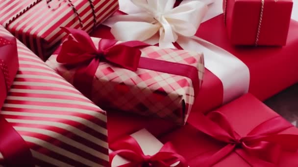 クリスマスプレゼント ボクシングの日と伝統的な休日プレゼント 古典的な赤とピンクのクリスマスギフトボックス 誕生日 バレンタインデーと休日のコンセプトのための豪華なプレゼントを包んだ — ストック動画