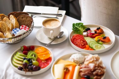 Lüks otel ve beş yıldızlı oda servisi, çeşitli yemek tabakları, ekmek ve kahve seyahat ve konukseverlik markası olarak oda kahvaltısı.