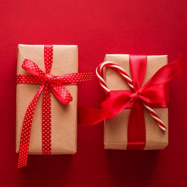 Noel hediyeleri, boks günü ve geleneksel bayram hediyeleri düz konum, kırmızı arka planda klasik Noel hediye kutuları, bayram süsleri ve düz dizayn dekorasyonları ile paketlenmiş