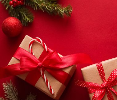 Noel hediyeleri, boks günü ve geleneksel bayram hediyeleri düz konum, kırmızı arka planda klasik Noel hediye kutuları, bayram süsleri ve düz dizayn dekorasyonları ile paketlenmiş