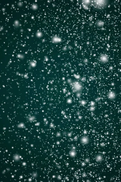 冬の休日や冬の背景 クリスマスや雪の休日のデザインのための抽象的な雪のシーンとしてお祝いの緑の背景に落ちる白い雪 雪のフレークのボケや雪の粒子 — ストック写真