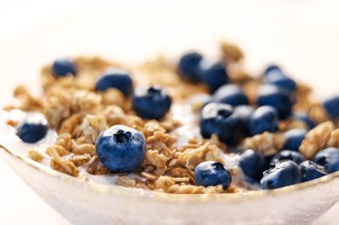 Kahvaltı fikri ve lezzetli yemek, kahvaltılık tahıl taneleri laktozsuz yoğurt ve taze organik yaban mersini kasesi, lezzetli ve sağlıklı tarif, yemek fotoğrafçılığı.