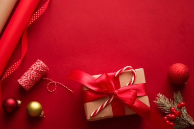 Noel hazırlığı, boks günü ve bayram hediyeleri, Noel hediyesi kağıtları ve kırmızı arka plandaki hediye kutuları için kurdeleler paketleme araçları ve dekorasyonlar olarak sunuluyor.