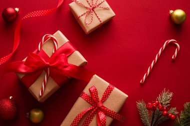 Noel hediyeleri, boks günü ve geleneksel bayram hediyeleri düz konum, kırmızı arka planda klasik Noel hediye kutuları, bayram süsleri ve düz dizayn dekorasyonları ile paketlenmiş