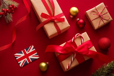 Noel, boks günü ve Birleşik Krallık bayrağı, geleneksel bayram hediyeleri, kırmızı arka planda hediyeler düzlük, paketlenmiş hediyeler ve bayram süsleri, düz dizayn süslemeleri.