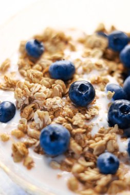 Kahvaltı fikri ve lezzetli yemek, kahvaltılık tahıl taneleri laktozsuz yoğurt ve taze organik yaban mersini kasesi, lezzetli ve sağlıklı tarif, yemek fotoğrafçılığı.