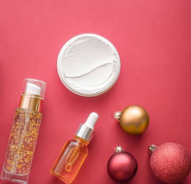Güzellik ürünleri ve Noel, lüks cilt bakımı, spa ve kozmetik saç veya vücut bakım ürünleri mercan arka planda yatar, sağlık kozmetiği tatil hediyesi olarak sunulur, çevrimiçi alışveriş dağıtımı, düz konum.