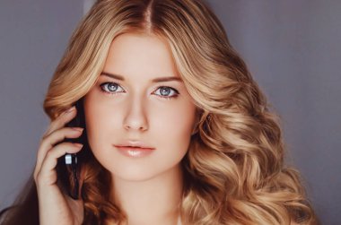 Güzel bir kadın arıyor ve cep telefonundan konuşuyor..