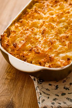 Rahatlatıcı yemekler ve geleneksel İngiliz mutfağı, kırsal kesimdeki ahşap masa üzerinde fırında balık turtası, ev yapımı yemek tarifi fikri.