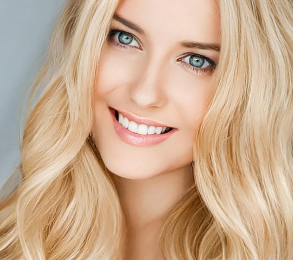 Beautiful blonde woman smiling, white teeth smile.