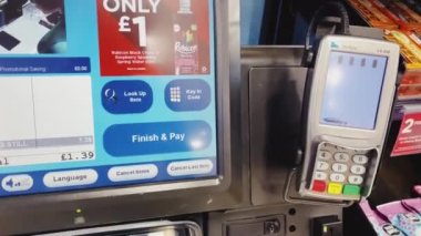Luton, Bedfordshire, England, United Kingdom circa January 2023: Paying with self checkout at London Luton Airport, self-service payment at the supermarket