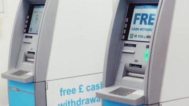 Luton, Bedfordshire, England, United Kingdom circa January 2023: Cash machine, bank ATM and currency exchange at London Luton Airport