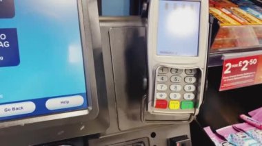 Luton, Bedfordshire, England, United Kingdom circa January 2023: Paying with self checkout at London Luton Airport, self-service payment at the supermarket