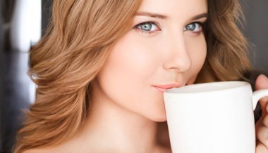 Beautiful woman having a cup of tea in the morning at home.
