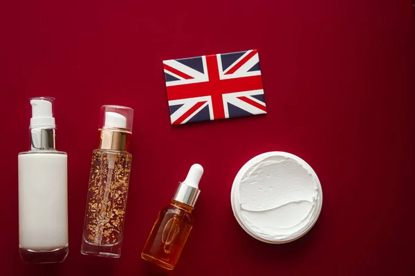 Skincare cosmetics and anti-aging beauty products, United Kingdom shopping delivery, luxury skin care bottles, oil, serum, face cream and UK flag on red background.