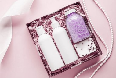 Güzellik kutusu aboneliği, lüks cilt bakımı ve vücut bakım ürünleri, süt losyonu, banyo tuzu, sabun, duş jeli pembe arka planda yatar vaziyette, spa kozmetik ürünleri tatil hediyesi olarak, online alışveriş