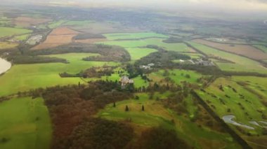 Aerial view of rolling hills of the English countryside landscape, beautiful nature, rural fields and green pastures on a sunny day in England, United Kingdom.