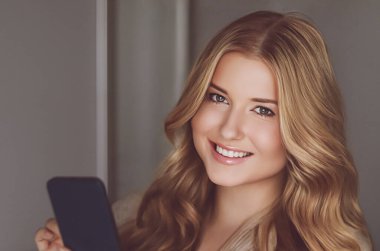 Güzel bir kadın cep telefonuyla video görüşmesi yapıyor, akıllı telefondan online alışveriş yapıyor..