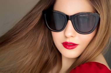 Beauty, fashion and style, face portrait of beautiful woman wearing stylish cat eye sunglasses and red lipstick make-up, luxury accessory and summer lifestyle, glamour and chic look.