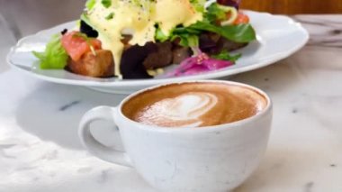 Kafeteryadaki mermer masada bir fincan kahve kapuçino.