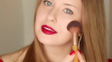 Güzel bir kadın makyaj fırçasıyla pudra sürüyor ve gülümsüyor, kozmetik ürünler, doğal güzellik, cilt bakımı ve makyaj malzemesi, yaşam tarzı portresi