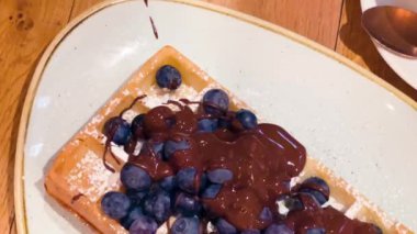 Antwerp, Belçika 'daki kafeteryada yabanmersinli ve çikolatalı geleneksel Belçika waffleları, yavaş çekim videosu