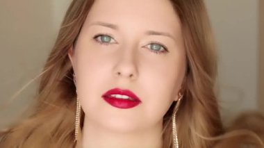 Mükemmel beyaz dişli gülümseyen mutlu bir kadın yakın plan portre içinde poz veriyor, uzun saçlı, altın küpeli ve kırmızı rujlu bir kadın model, mücevher modası ve güzellik.