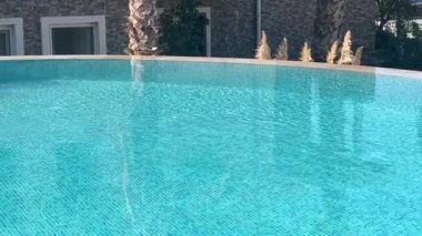 Lüks villa deniz tatil köyünde sonsuz yüzme havuzu manzarası, durgun kristal mavi su ve yaz rahatlaması, yavaş çekim video