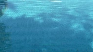 Yaz tatili arka planı olarak yüzme havuzu suyu, kristal mavi doku, yaz ve seyahat ilham kaynağı, yavaş çekim video