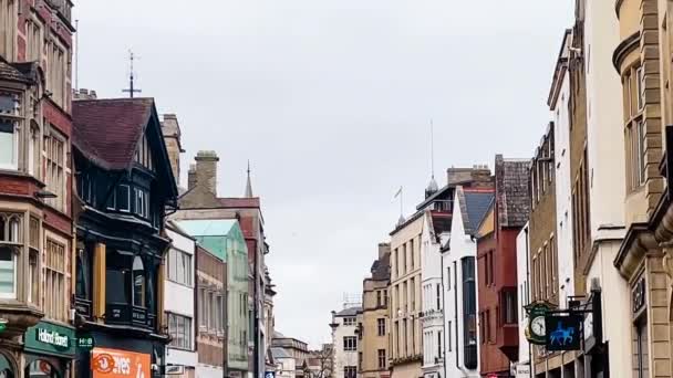 2023年3月のイギリス オックスフォードシャー州オックスフォード市 オックスフォード市内中心部のショッピングストリート 歴史的建造物 ショップ 店舗の建築 スローモーションで歩く人々 イギリス — ストック動画