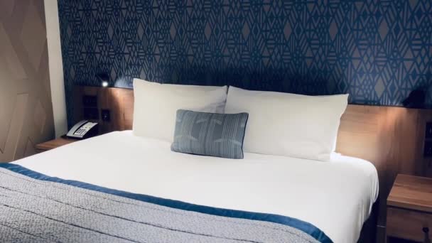 モダンなホテルの客室 コンテンポラリーアートデコデザイン 幾何学模様の壁紙と装飾的な枕付きのベッド スローモーションビデオ — ストック動画