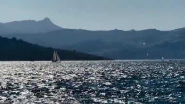 Mavi suları, uçurumları ve gün batımında dağları olan kıyı sahili, yaz tatili.