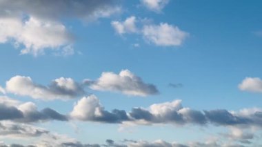 Geniş mavi gökyüzü yumuşak, tüylü bulutlarla bezenmiş, İngiliz kırsalındaki sükunetin özünü yakalıyor.