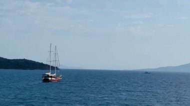 Geleneksel yelkenli gemi sakin deniz sularında geziyor, yaz tatili seyahati