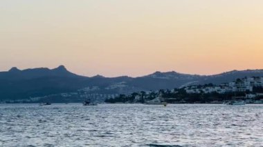 Mavi suları, uçurumları ve gün batımında dağları olan kıyı sahili, yaz tatili.